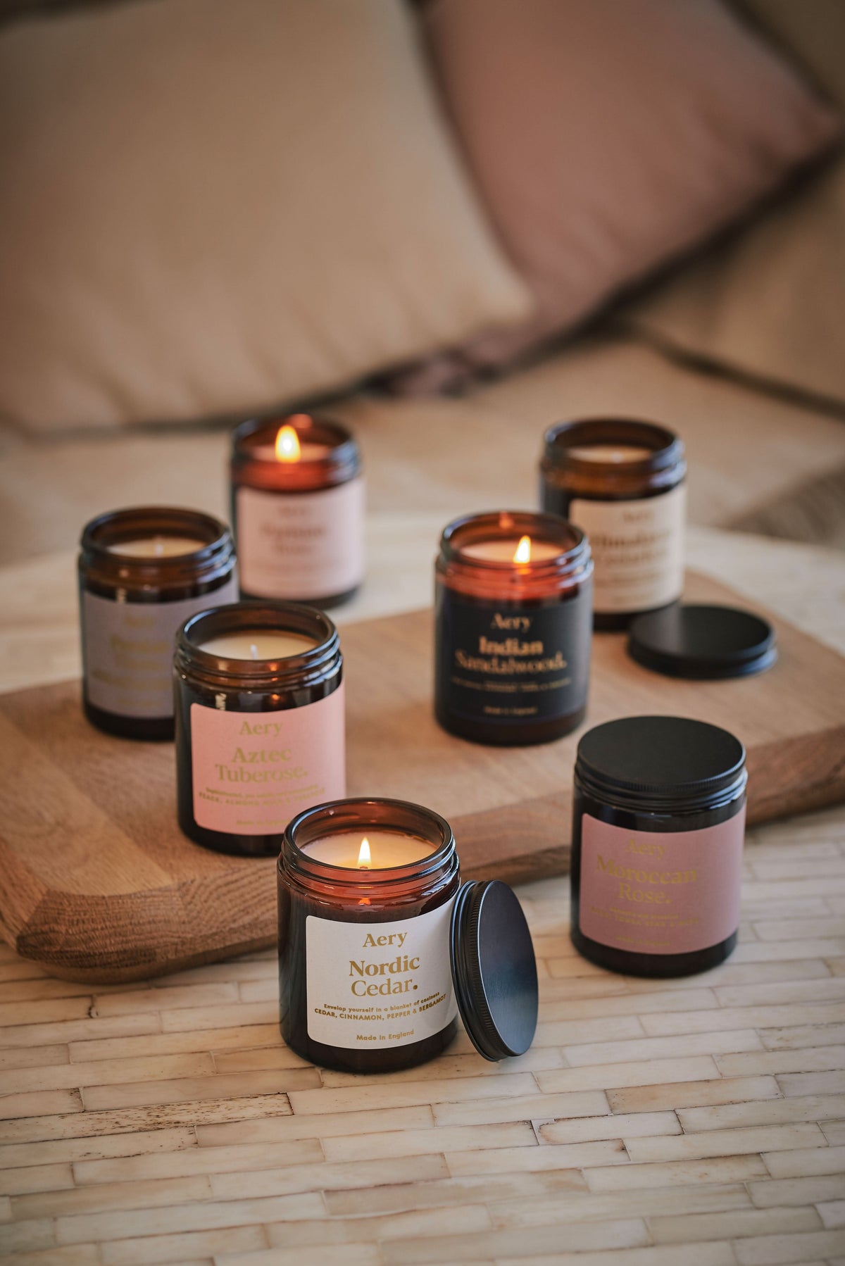 Collection of Fernweh jar candles by Aery displayed on wooden tray and cream table