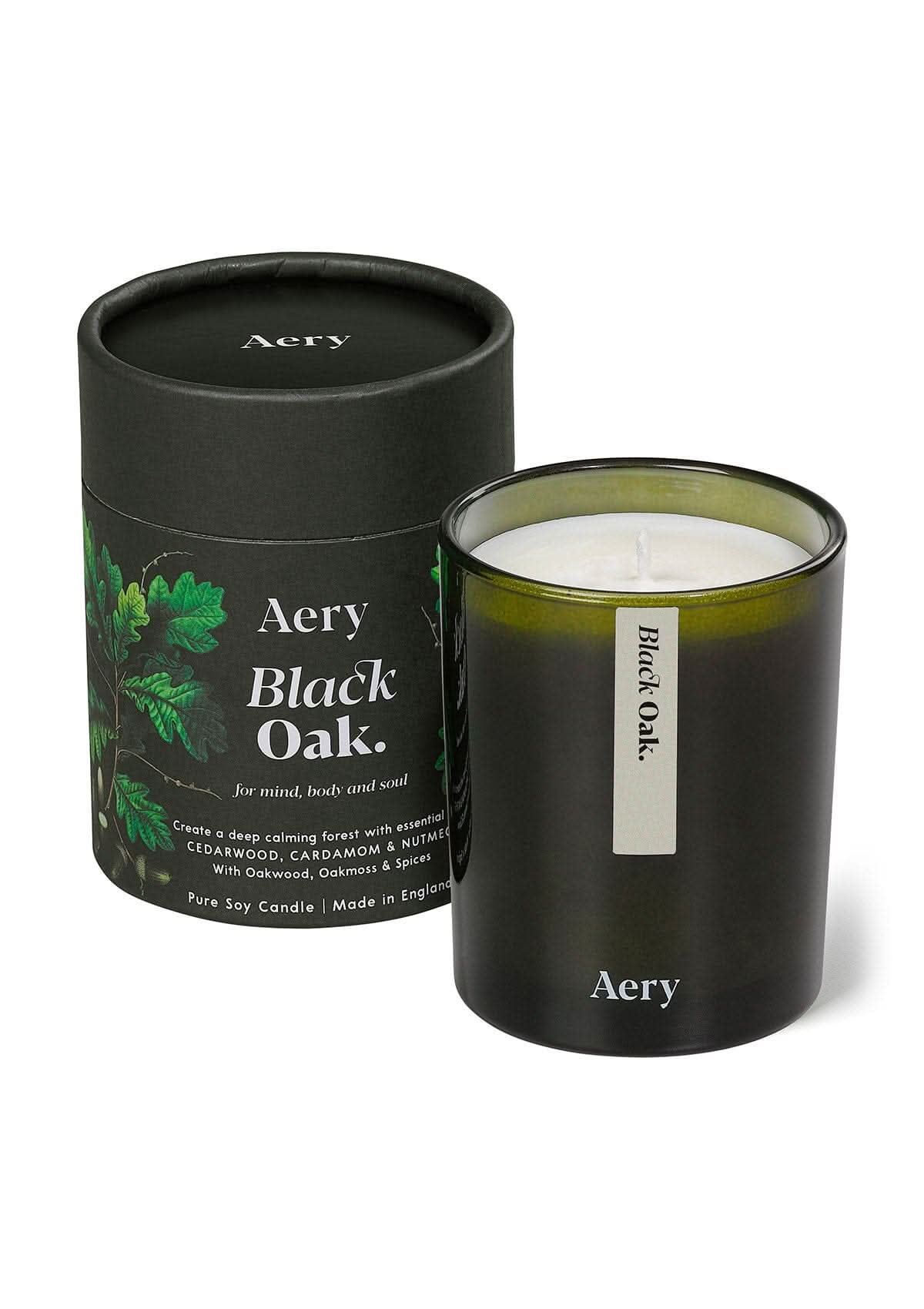 Green Black Oak glass scented candle displayed next to product packaging  on white bacground